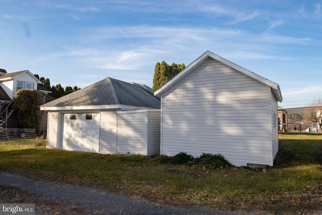 view of home's exterior featuring a garage and an outbuilding