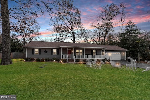 ranch-style home featuring a yard, a porch, and a garage