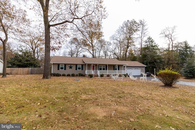 single story home with covered porch, a garage, and a front lawn