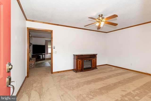 unfurnished living room with light carpet, a brick fireplace, ceiling fan, ornamental molding, and a textured ceiling