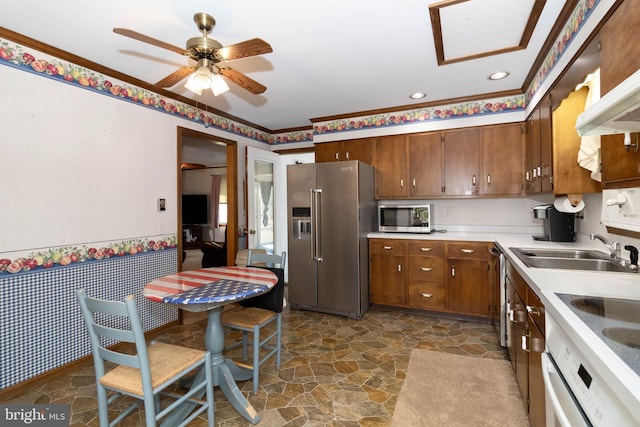 kitchen with ceiling fan, sink, crown molding, and appliances with stainless steel finishes