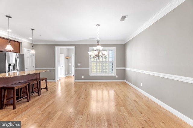 dining space with a chandelier, light hardwood / wood-style floors, and crown molding