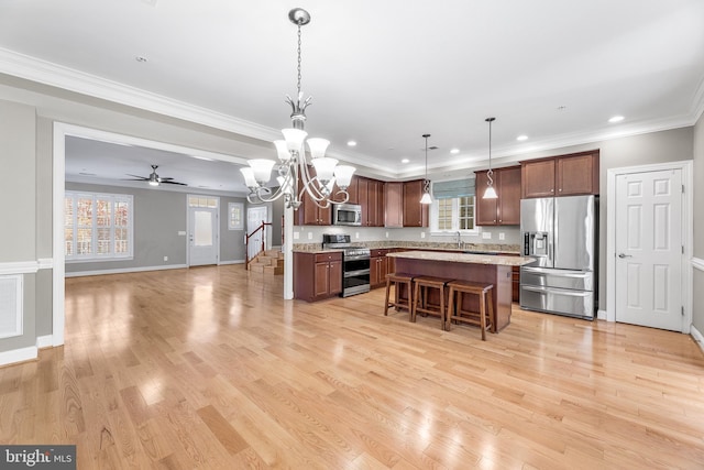 kitchen with pendant lighting, plenty of natural light, stainless steel appliances, and a breakfast bar