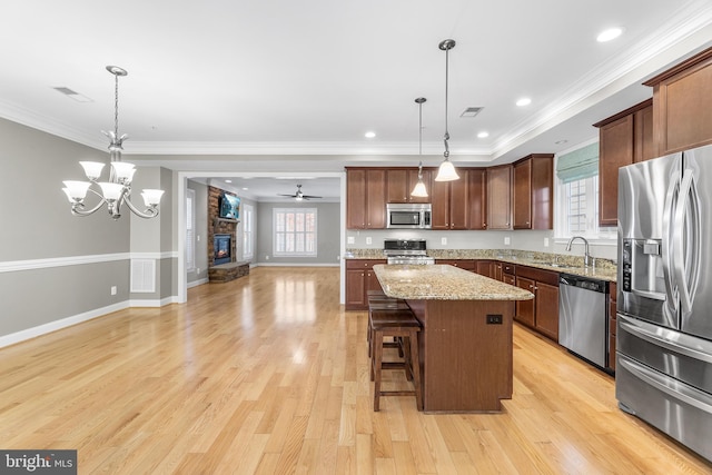 kitchen featuring pendant lighting, light wood-type flooring, stainless steel appliances, and a kitchen island