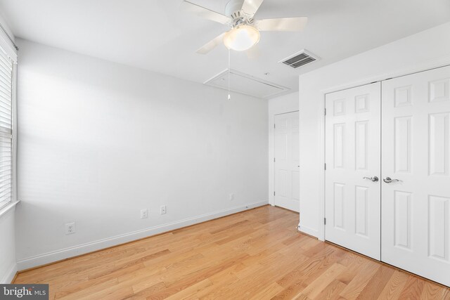 unfurnished bedroom with ceiling fan, light wood-type flooring, and a closet