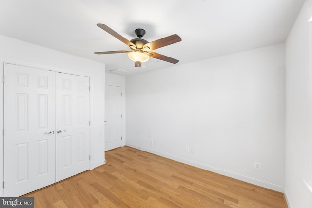 unfurnished bedroom with light hardwood / wood-style flooring, a closet, and ceiling fan