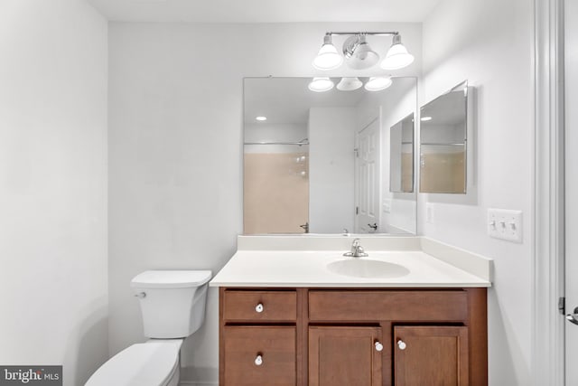 bathroom featuring a shower, vanity, and toilet