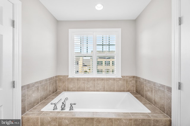 bathroom featuring tiled tub