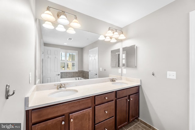 bathroom featuring a bathtub, vanity, and tile patterned flooring