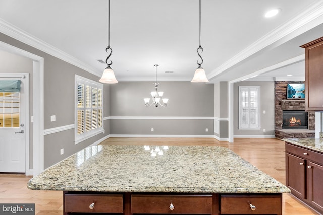 kitchen featuring light hardwood / wood-style flooring, plenty of natural light, a kitchen island, and crown molding