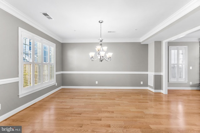 unfurnished dining area with a chandelier, ornamental molding, and light wood-type flooring