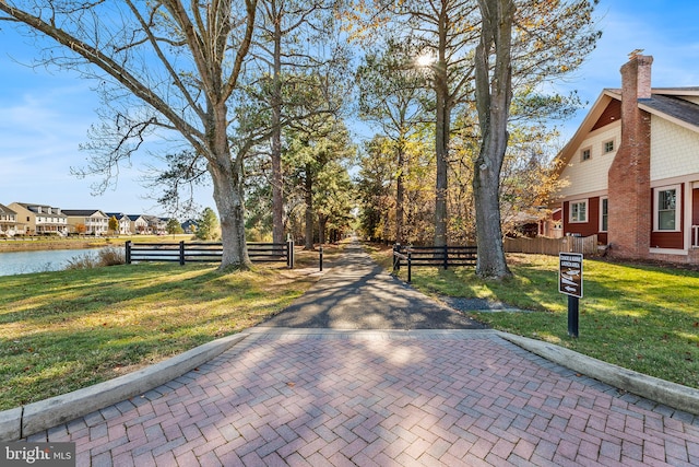 surrounding community featuring a water view and a lawn