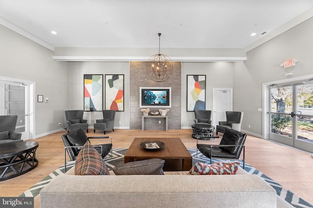 living room with light hardwood / wood-style flooring, a chandelier, and ornamental molding