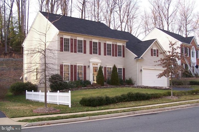 colonial house with a front lawn and a garage