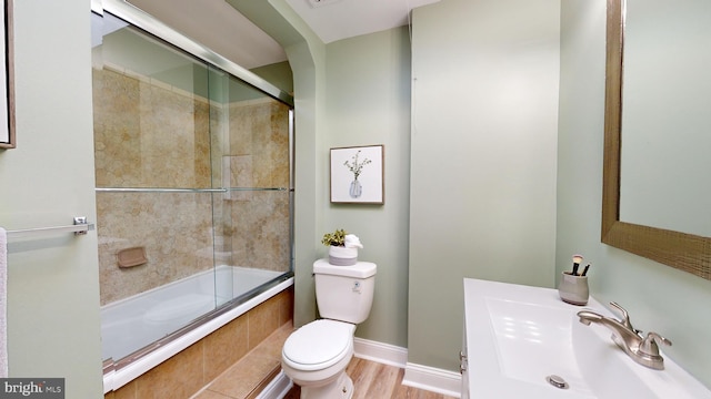 full bathroom featuring shower / bath combination with glass door, toilet, sink, and hardwood / wood-style flooring