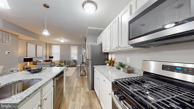 kitchen featuring white cabinets, light hardwood / wood-style floors, and appliances with stainless steel finishes