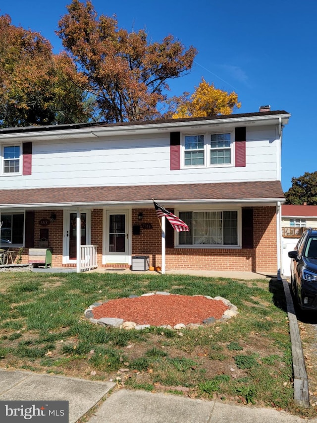 view of front of house with covered porch and a front yard