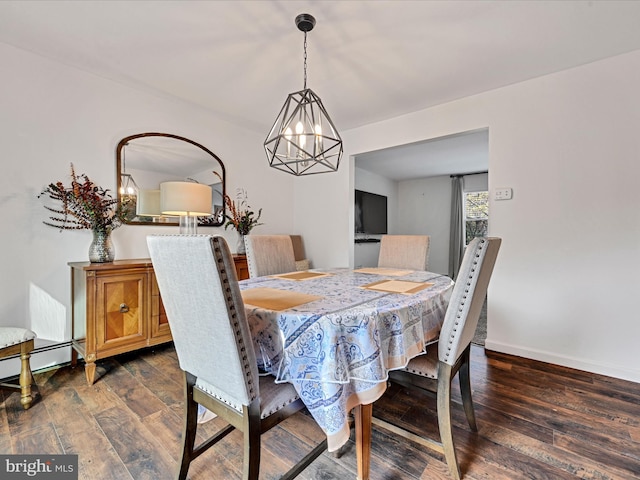 dining space with a notable chandelier, dark hardwood / wood-style floors, and a baseboard heating unit