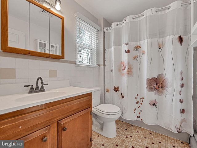 bathroom featuring vanity, tile patterned flooring, a shower with shower curtain, toilet, and tile walls