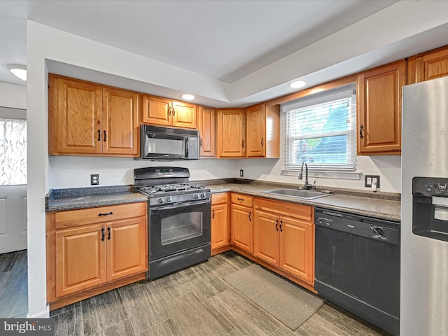 kitchen with black appliances, dark hardwood / wood-style floors, and sink