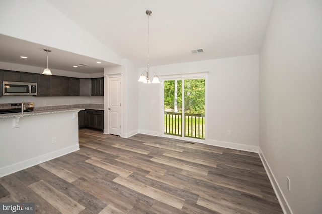 kitchen featuring dark hardwood / wood-style flooring, light stone counters, dark brown cabinets, stainless steel appliances, and high vaulted ceiling