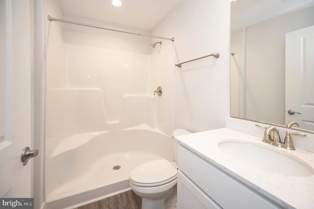 bathroom with vanity, hardwood / wood-style flooring, toilet, and walk in shower