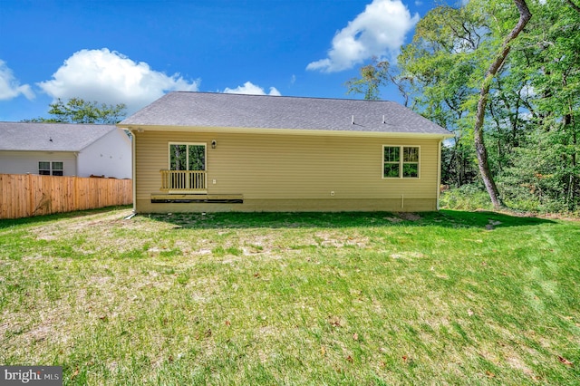 rear view of house featuring a lawn