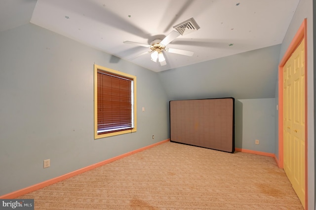 additional living space with ceiling fan, light colored carpet, and lofted ceiling