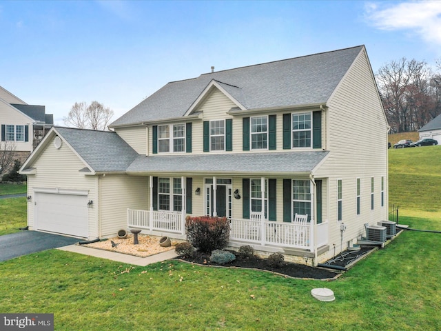 view of front of property with central air condition unit, a front lawn, covered porch, and a garage