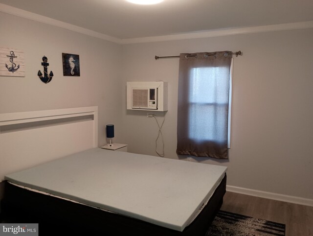 bedroom featuring an AC wall unit and dark wood-type flooring