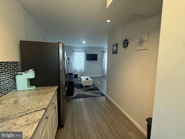 6406 Coastal Hwy Unit 201, Ocean City, MD 21842 - kitchen featuring stainless steel refrigerator with ice dispenser, wood finished floors, light stone counters, baseboards, and recessed lighting