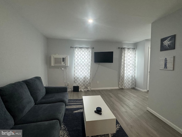 living room featuring hardwood / wood-style floors and an AC wall unit
