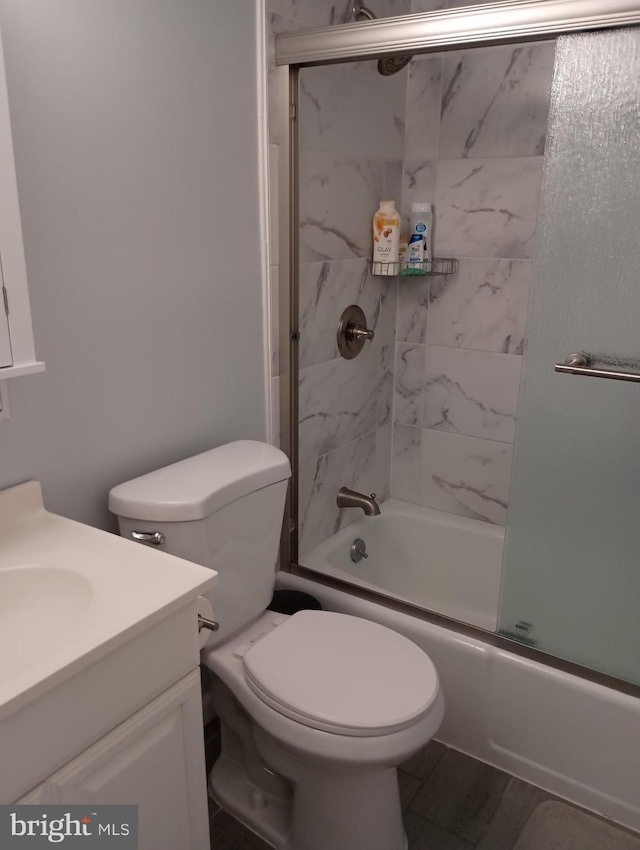 full bathroom featuring vanity, enclosed tub / shower combo, and toilet