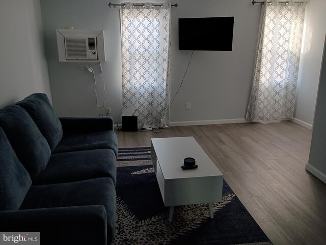 living room featuring a wall unit AC and hardwood / wood-style floors