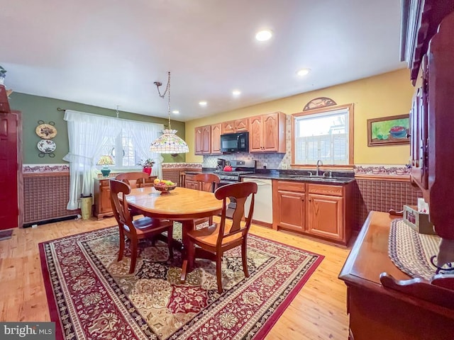 dining space with light hardwood / wood-style flooring, plenty of natural light, and sink