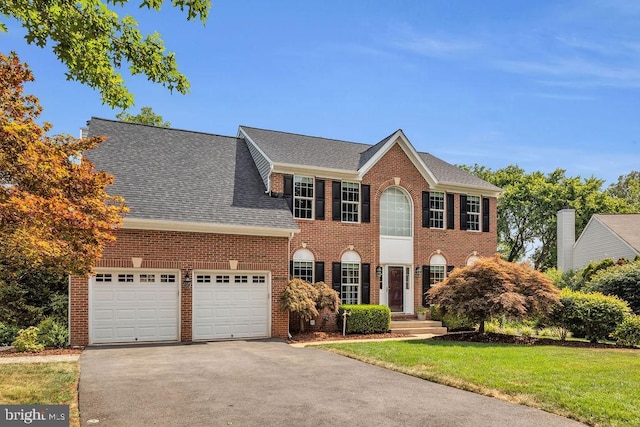 colonial home with a garage and a front yard