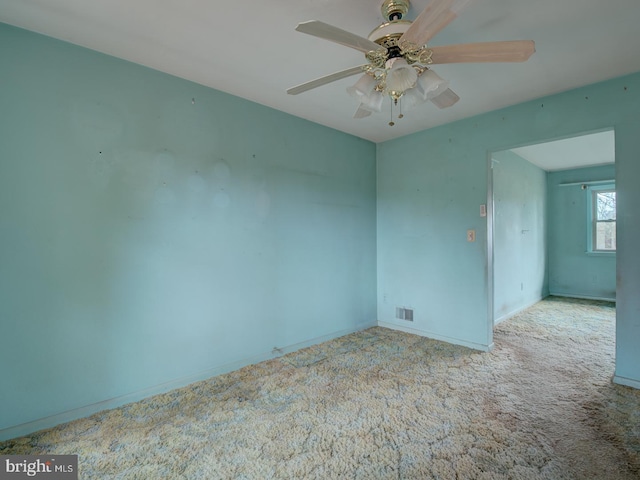 carpeted spare room featuring ceiling fan