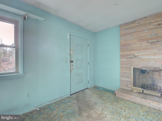 unfurnished living room with carpet floors and a large fireplace