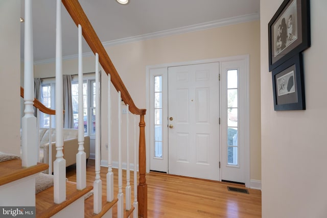 entryway featuring light hardwood / wood-style floors, plenty of natural light, and crown molding