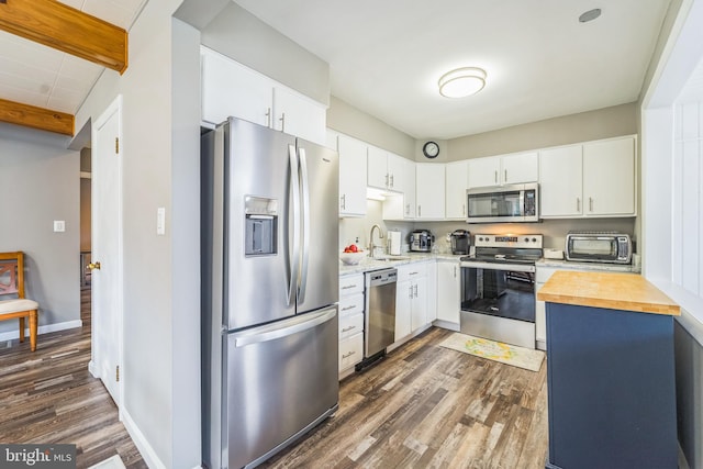 kitchen featuring white cabinets, stainless steel appliances, dark wood-type flooring, and sink