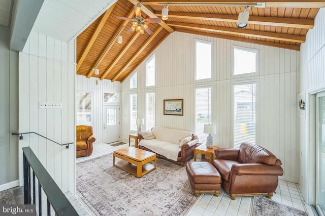 sunroom / solarium featuring a wealth of natural light, vaulted ceiling with beams, ceiling fan, and wood ceiling