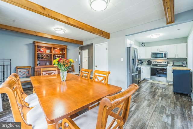 dining area with beam ceiling and dark hardwood / wood-style floors