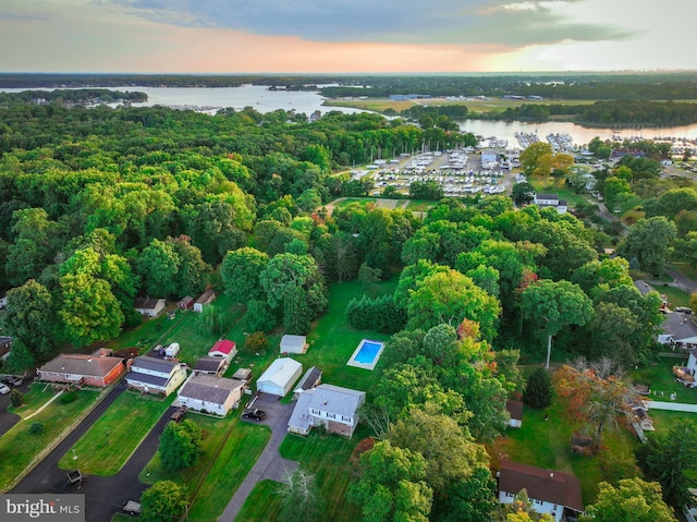 aerial view at dusk featuring a water view