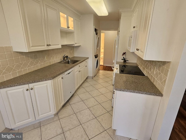 kitchen featuring decorative backsplash, white appliances, light tile patterned floors, white cabinetry, and stacked washer / drying machine