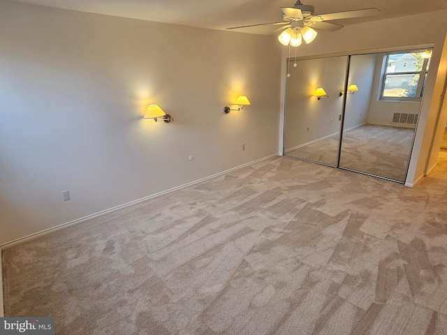 unfurnished bedroom featuring light colored carpet, a closet, and ceiling fan