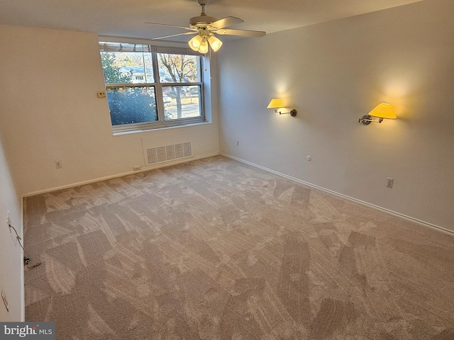 carpeted spare room with ceiling fan