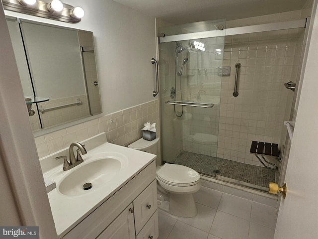 bathroom featuring tile patterned flooring, vanity, a shower with door, and toilet