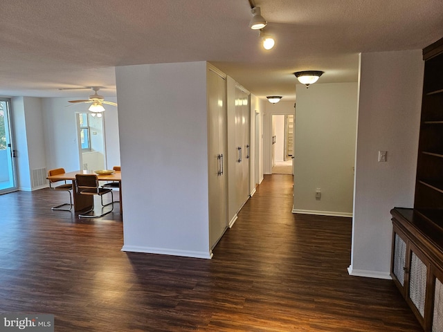 hallway with dark wood-type flooring and a textured ceiling