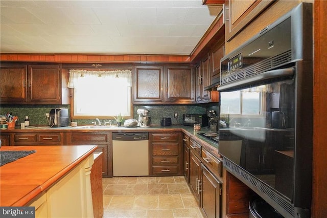 kitchen with backsplash, dishwashing machine, and plenty of natural light