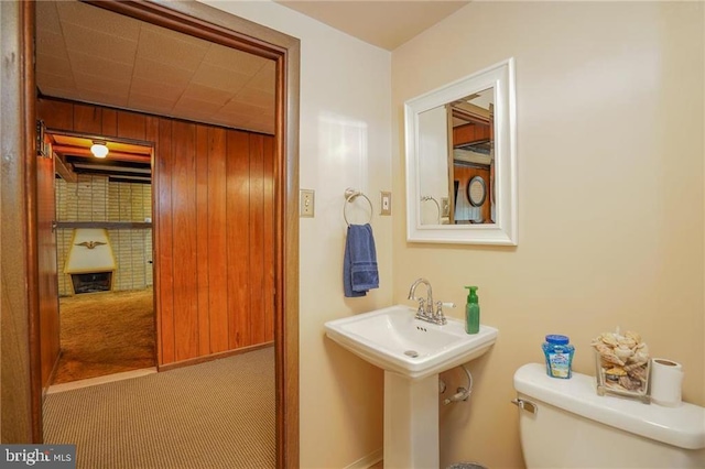 bathroom with wooden walls and toilet